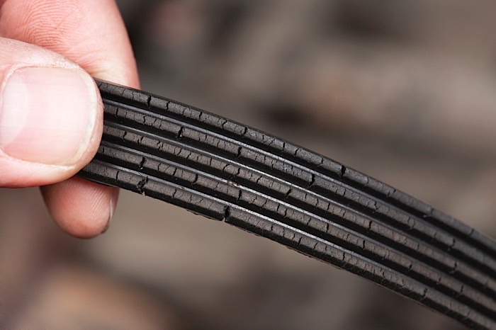 Photo of a worn and cracked serpentine belt.